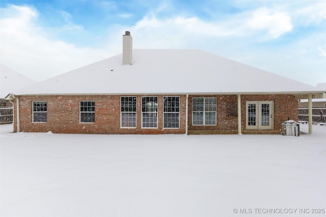 view of snow covered back of property