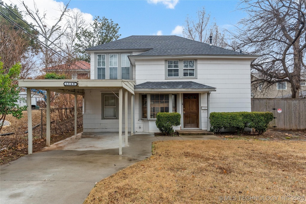 front facade featuring a front lawn and a carport