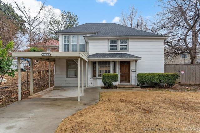 front facade featuring a front lawn and a carport