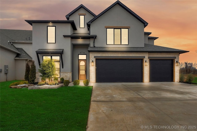 view of front of property featuring a garage and a lawn