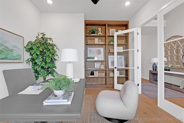 home office featuring hardwood / wood-style floors and french doors