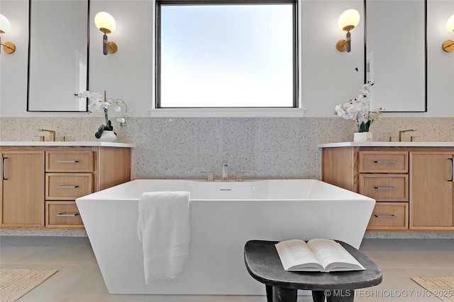 bathroom featuring vanity, a bath, and tile patterned floors