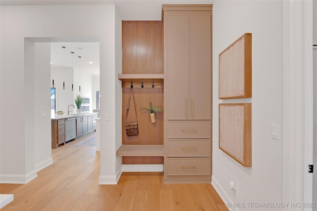 mudroom featuring sink and light hardwood / wood-style flooring