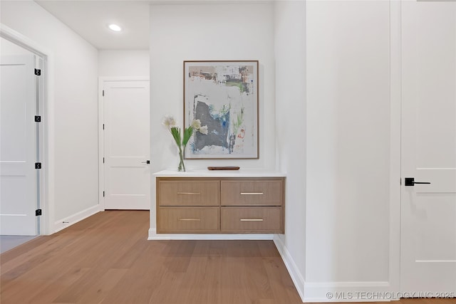 corridor with light hardwood / wood-style floors