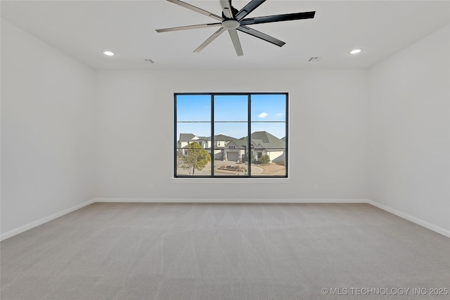 carpeted spare room featuring ceiling fan