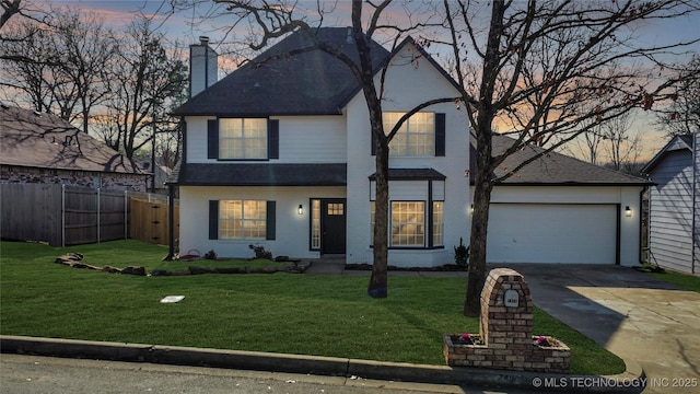 view of front of home with a garage and a yard