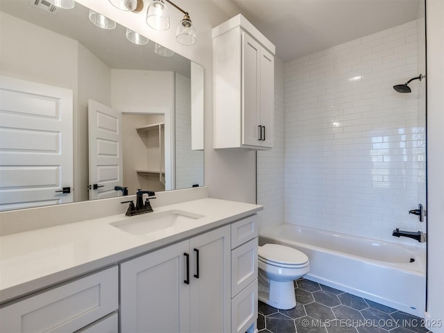 full bathroom with tiled shower / bath, vanity, toilet, and tile patterned flooring