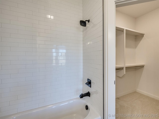 full bath featuring shower / tub combination, baseboards, and a walk in closet