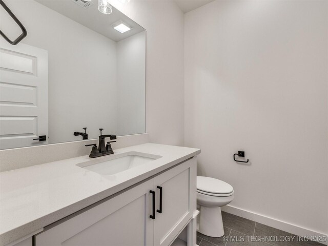 bathroom with tile patterned flooring, vanity, and toilet