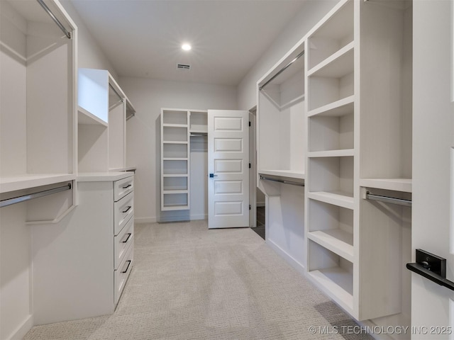 walk in closet featuring light colored carpet