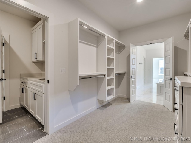 spacious closet featuring dark carpet