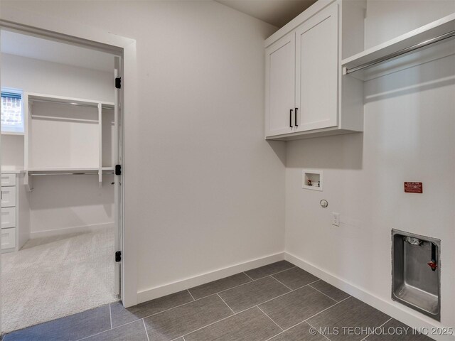 clothes washing area featuring cabinets, washer hookup, and dark carpet