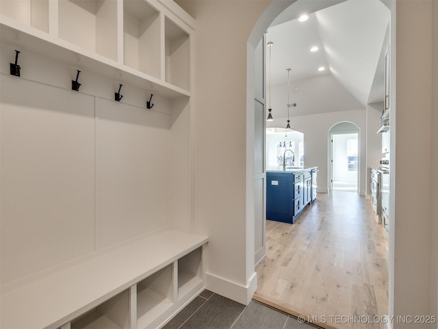 mudroom with vaulted ceiling, light hardwood / wood-style floors, and sink