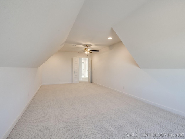 additional living space featuring ceiling fan, light colored carpet, and vaulted ceiling