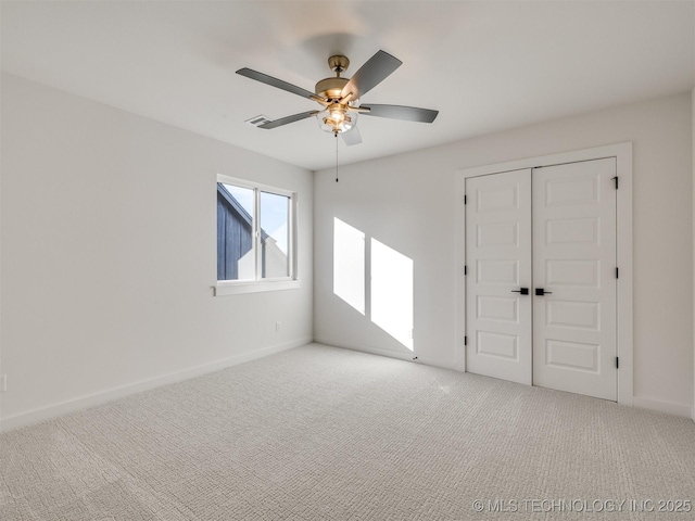 carpeted spare room featuring ceiling fan