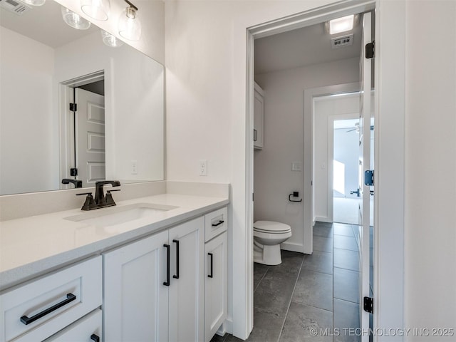 bathroom with visible vents, vanity, toilet, and tile patterned floors