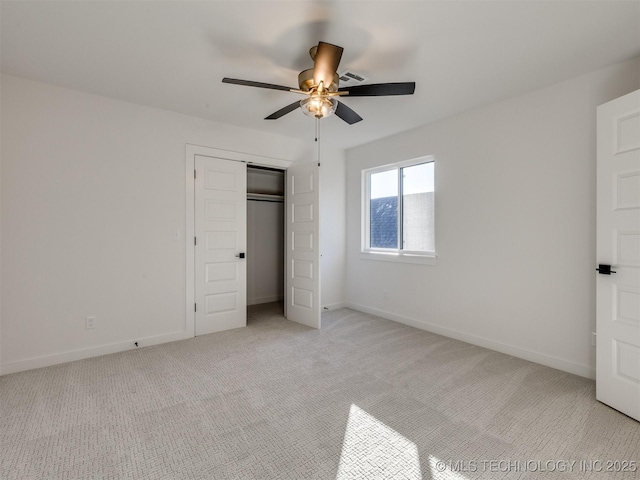 unfurnished bedroom featuring light carpet, ceiling fan, and a closet