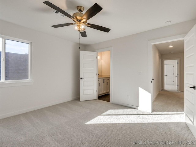 unfurnished bedroom with ceiling fan, ensuite bath, and light carpet