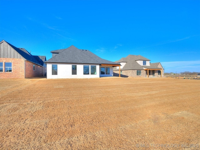 rear view of house featuring a lawn