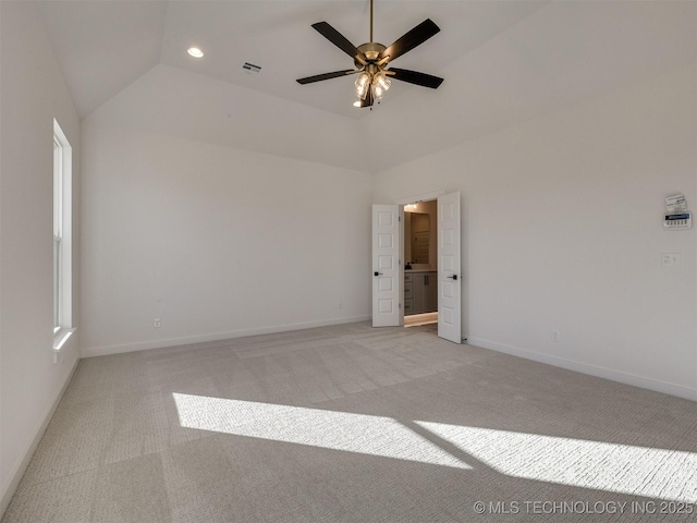 empty room featuring lofted ceiling, light carpet, and ceiling fan