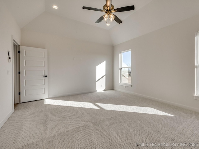 spare room with light carpet, baseboards, and vaulted ceiling