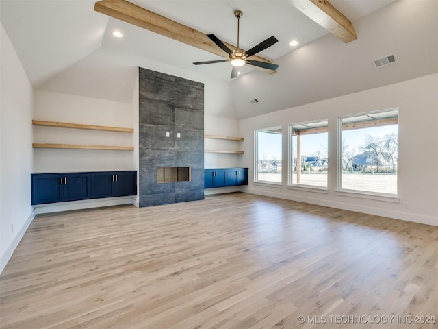 unfurnished living room with a tile fireplace, light wood-type flooring, ceiling fan, and beam ceiling