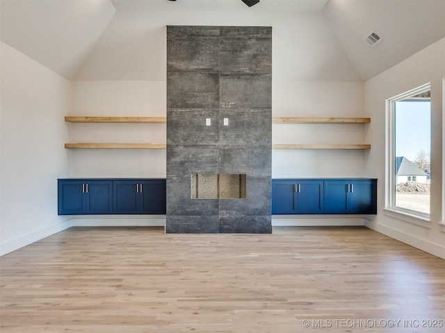 unfurnished living room featuring lofted ceiling and light hardwood / wood-style floors