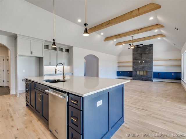 kitchen with pendant lighting, sink, white cabinets, a center island with sink, and light wood-type flooring