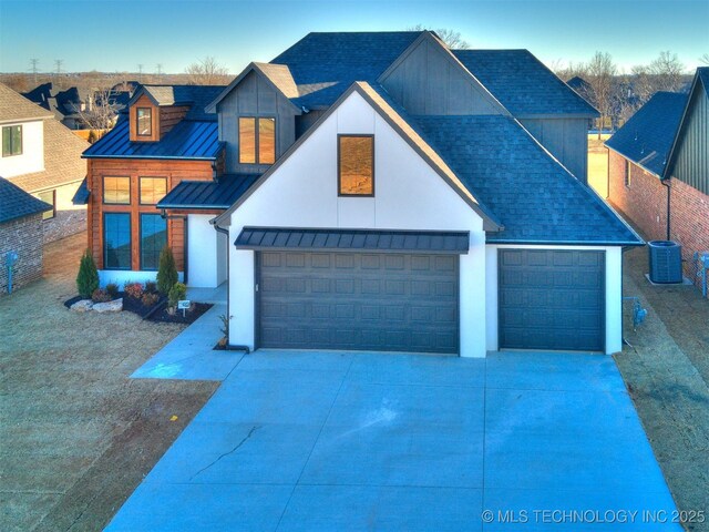 view of front of home with a garage and central air condition unit