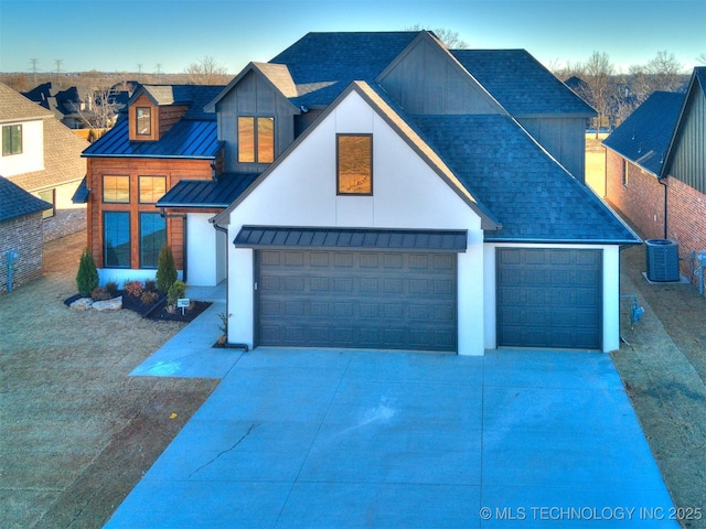 view of front facade featuring a standing seam roof, central AC unit, metal roof, and roof with shingles