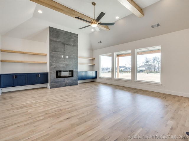 unfurnished living room featuring baseboards, visible vents, a tile fireplace, light wood-style flooring, and beamed ceiling