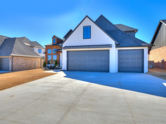 view of front of home featuring a shingled roof, concrete driveway, an attached garage, a standing seam roof, and metal roof