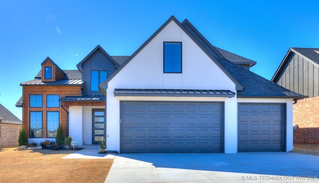 view of front facade featuring roof with shingles, an attached garage, a standing seam roof, metal roof, and driveway