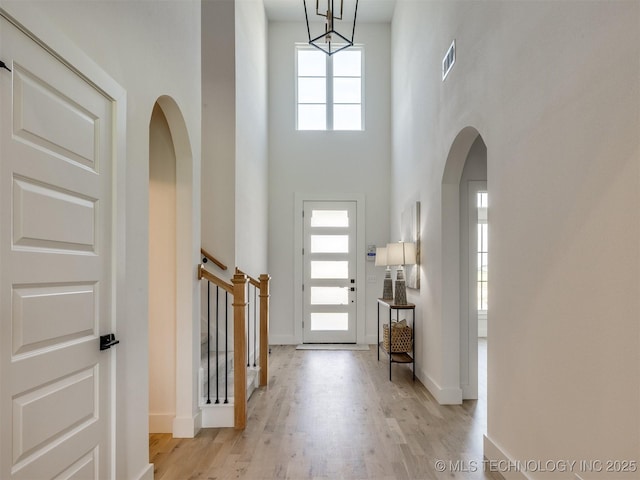 2508 E 135th Dr S, Bixby, OK 74008 - foyer with arched walkways, a towering ceiling, wood finished floors, baseboards, and stairs