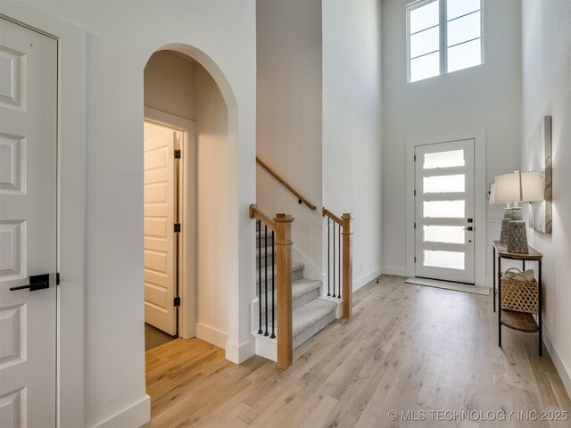 2508 E 135th Dr S, Bixby, OK 74008 - foyer entrance with wood finished floors, arched walkways, baseboards, a high ceiling, and stairs