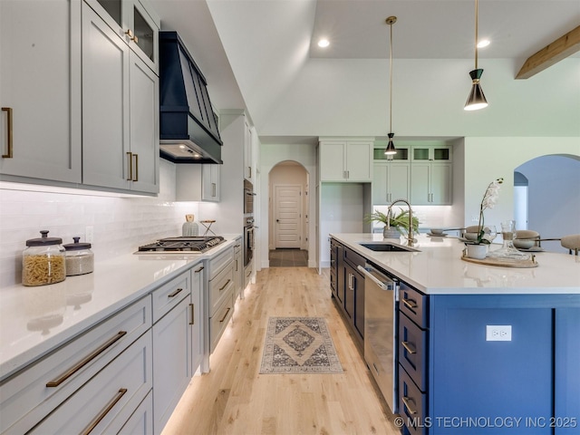 2508 E 135th Dr S, Bixby, OK 74008 - kitchen featuring arched walkways, a sink, premium range hood, stainless steel appliances, and light wood-type flooring