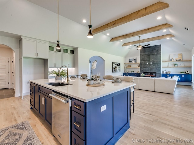 2508 E 135th Dr S, Bixby, OK 74008 - kitchen with arched walkways, a sink, stainless steel dishwasher, a tiled fireplace, and a ceiling fan