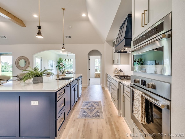 2508 E 135th Dr S, Bixby, OK 74008 - kitchen featuring a sink, arched walkways, custom range hood, lofted ceiling, and stainless steel appliances