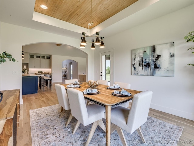 2508 E 135th Dr S, Bixby, OK 74008 - dining room featuring arched walkways, wood ceiling, a tray ceiling, light wood-style floors, and baseboards