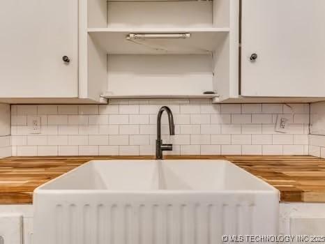 interior space featuring tasteful backsplash, sink, and wooden counters