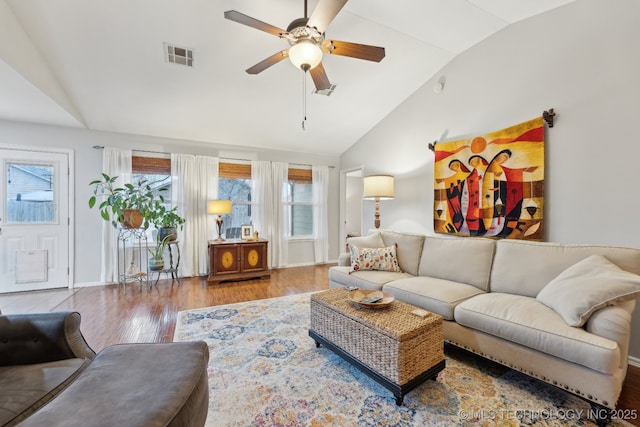 living room with hardwood / wood-style flooring, vaulted ceiling, and ceiling fan