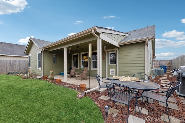 rear view of house with a yard, central AC unit, and a patio area