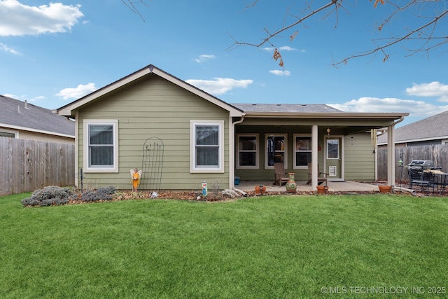 rear view of property featuring a patio area and a lawn