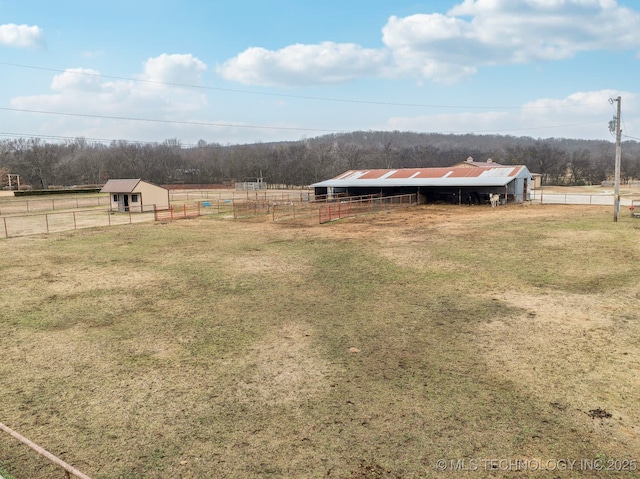 view of yard with a rural view and an outdoor structure