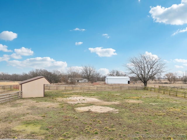 view of yard featuring a rural view and an outdoor structure