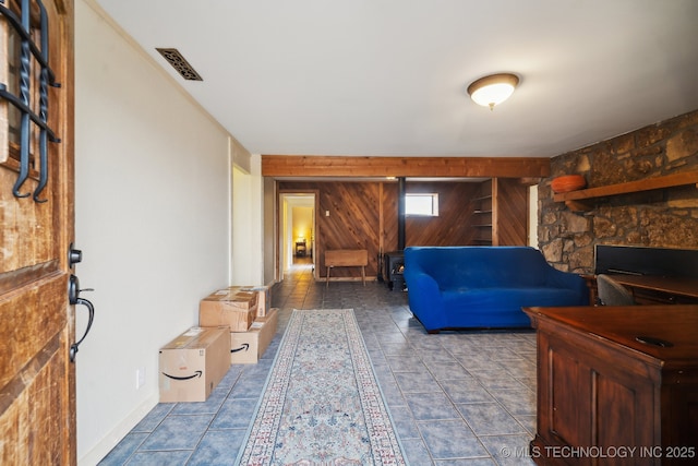 living room featuring tile patterned flooring and wood walls