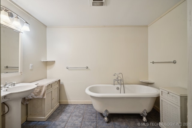 bathroom with a washtub, tile patterned flooring, crown molding, and sink