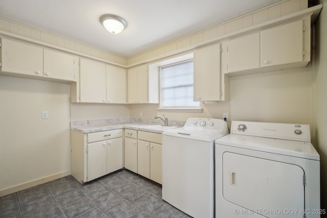 laundry room featuring sink, washer and clothes dryer, cabinets, and dark tile patterned floors