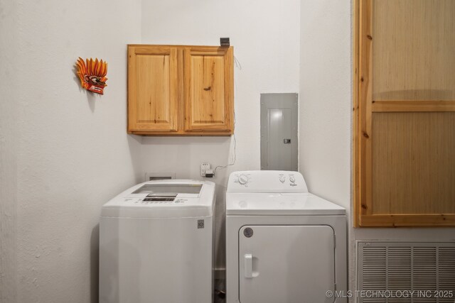 laundry area featuring cabinets, electric panel, and independent washer and dryer