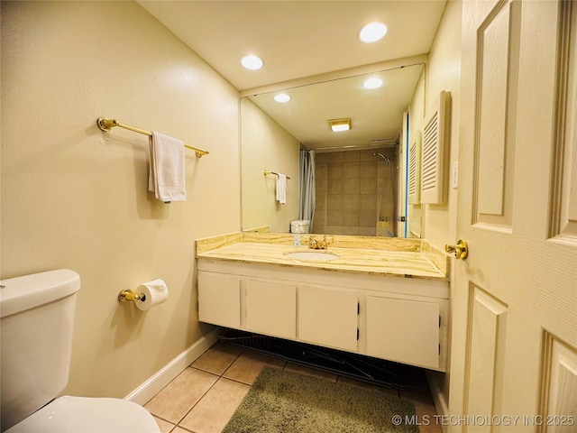 bathroom with tile patterned flooring, vanity, a tile shower, and toilet